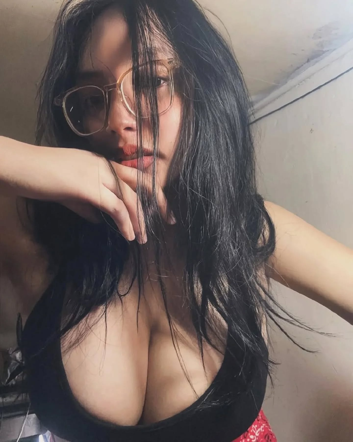 Woman with glasses, messy hair, and red lips.