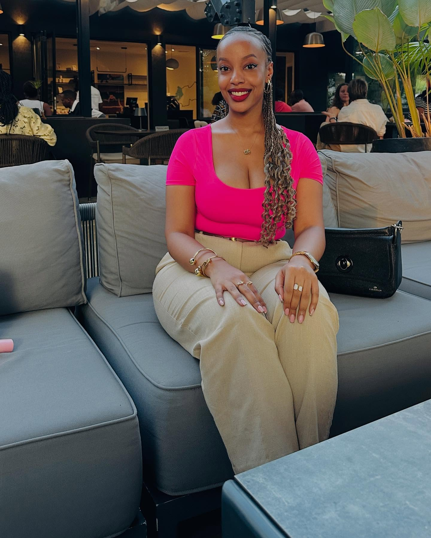 Woman in pink top and linen pants smiling.
