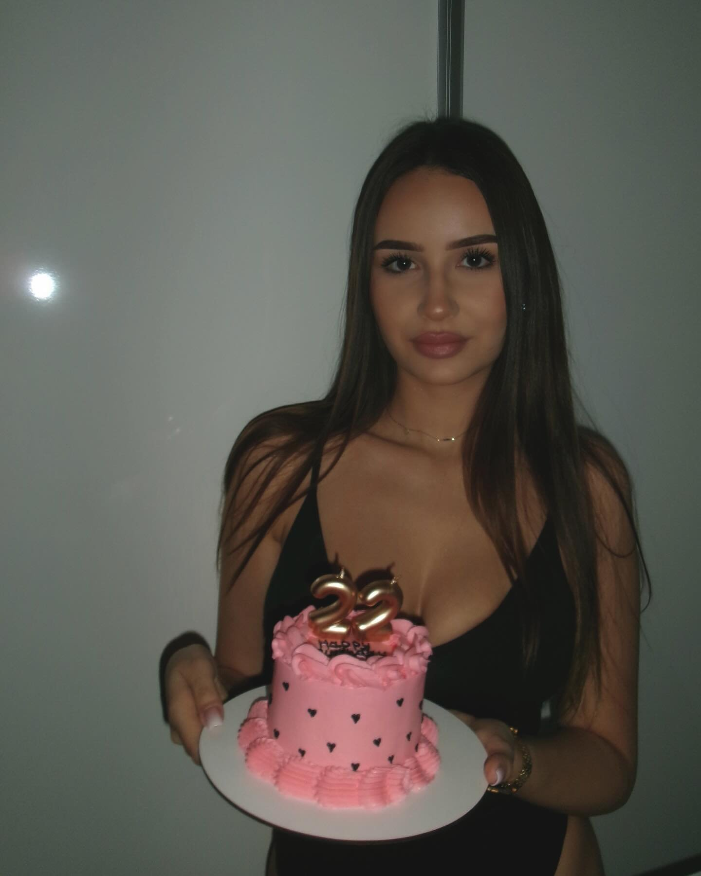 Brunette woman holding birthday cake.