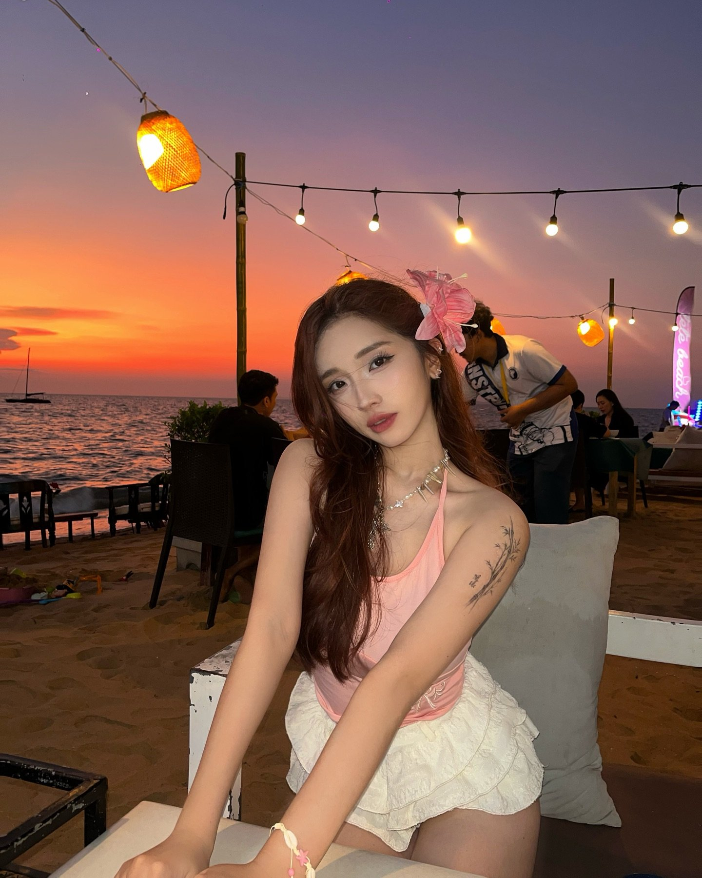 Woman in pink top and white skirt at sunset.