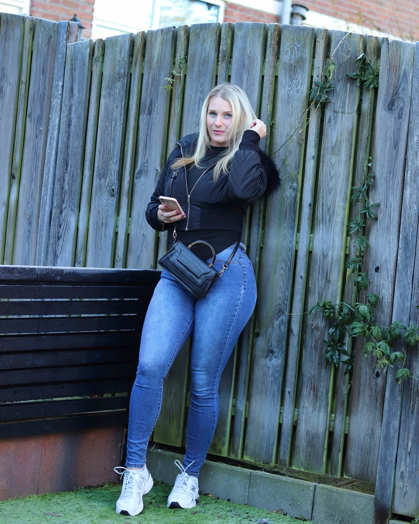 Woman in jeans and bomber jacket.
