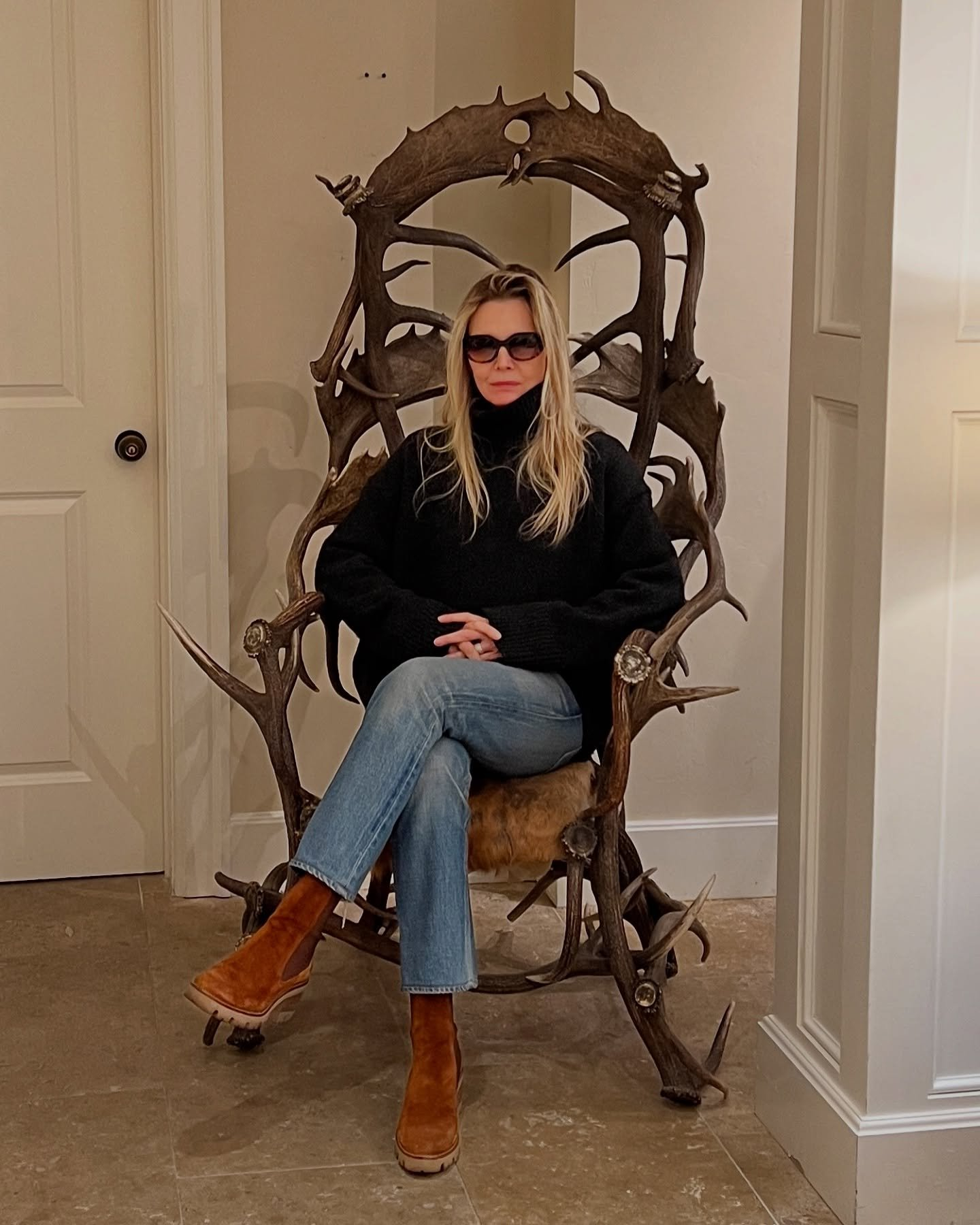 Michelle Pfeiffer on antler chair.